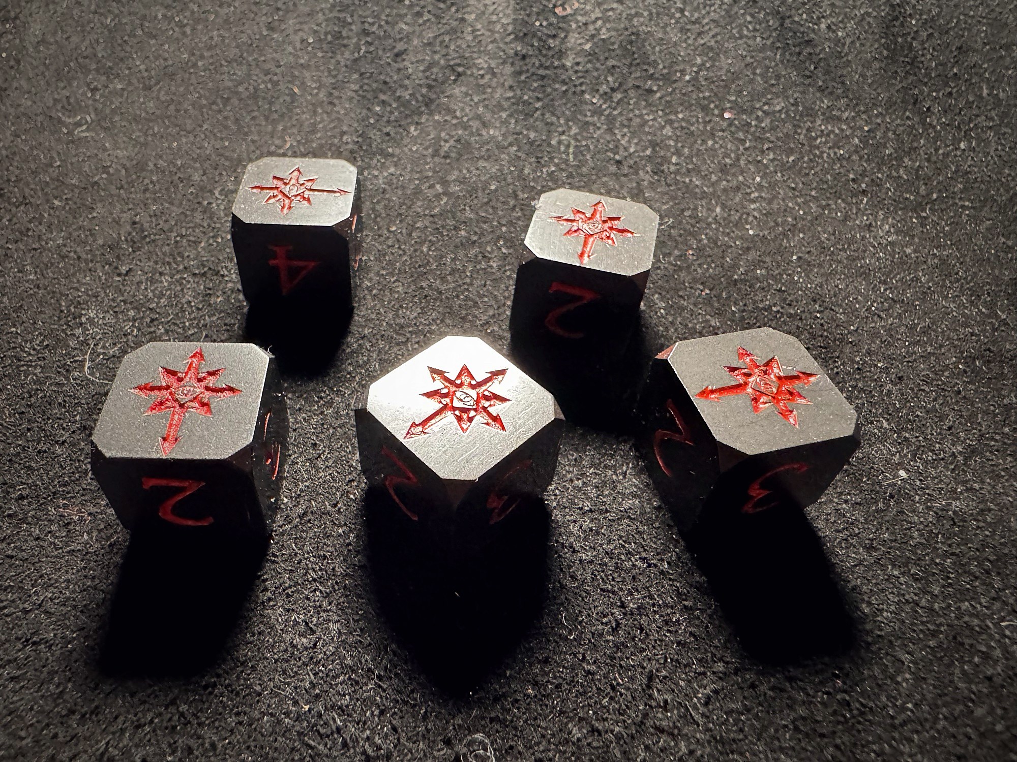 Dark composite dice with red chaos-star engravings arranged on a dark surface